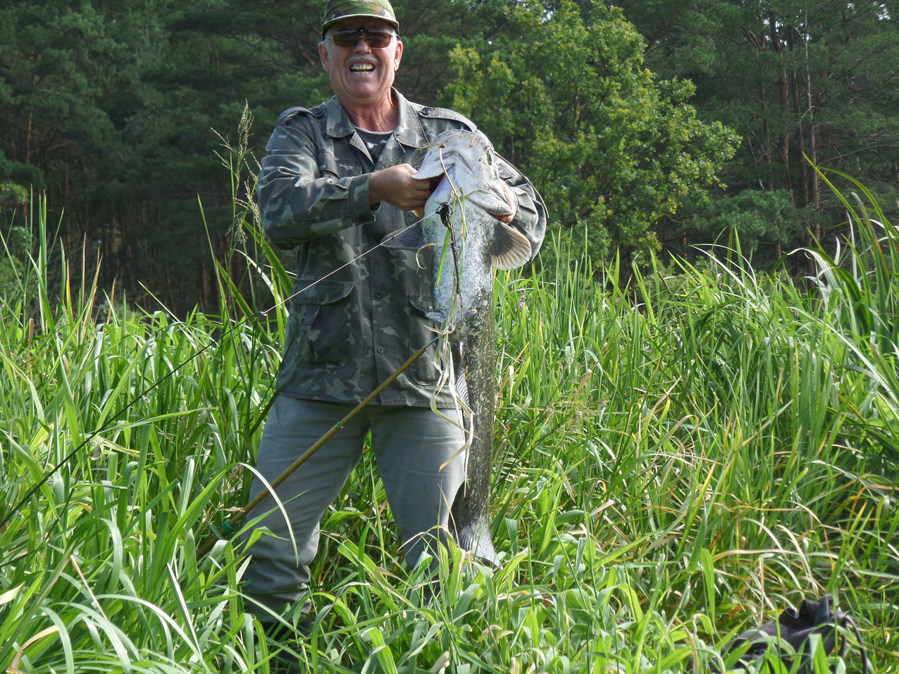 Blije visser met meerval